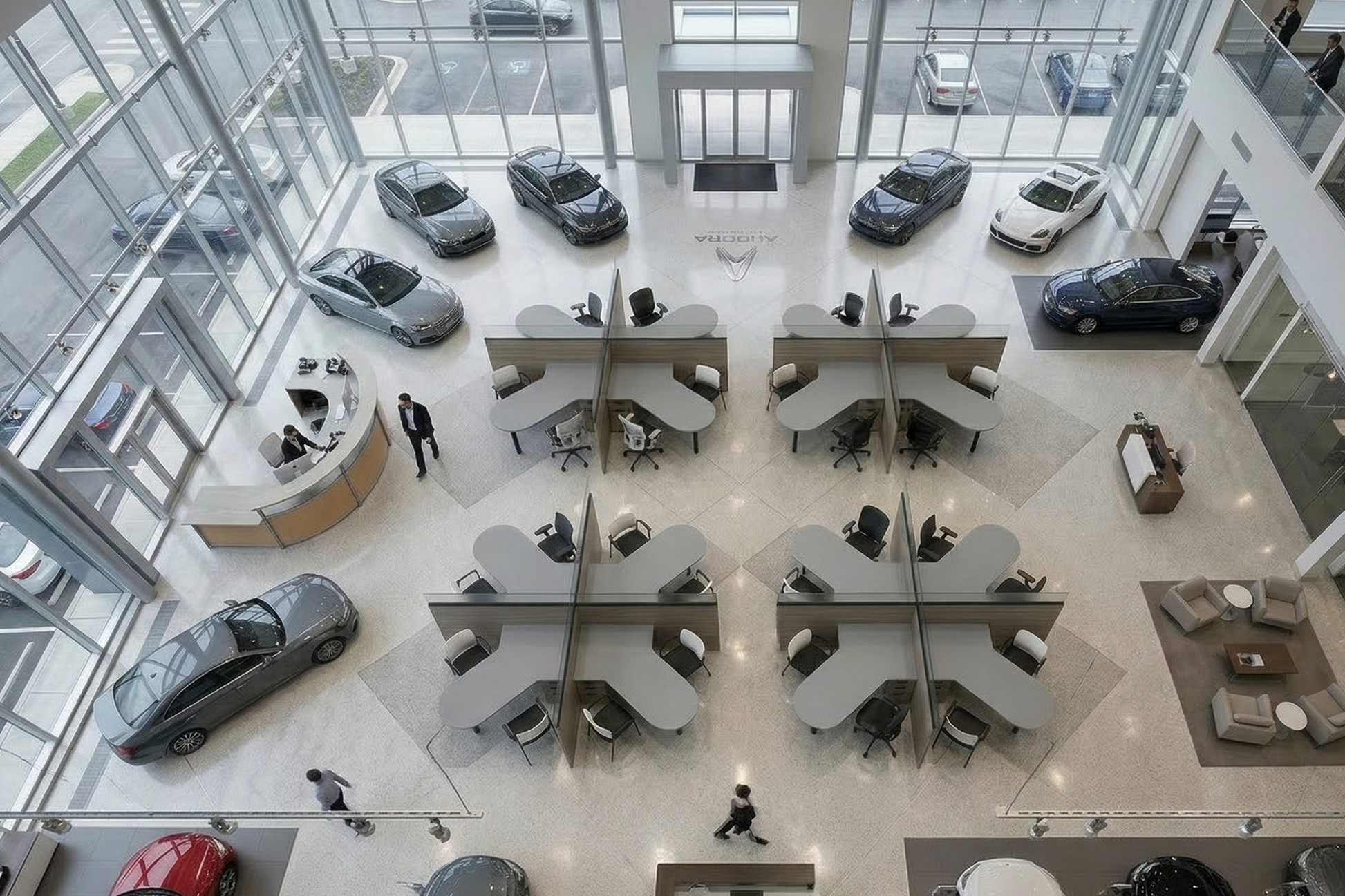 Modern car dealership with people working at desks, cars on display in the background