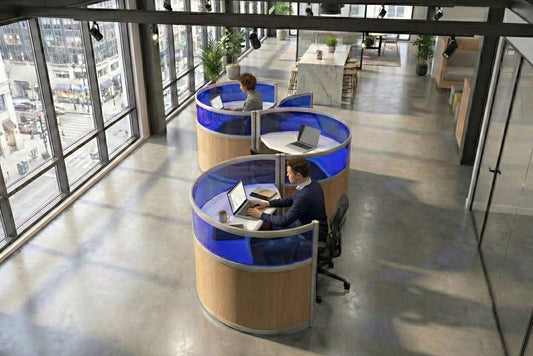 Modern office space with round pod touchdown workstations and people using laptops.