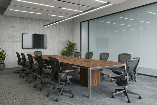 Modern conference room with a long wooden table and multiple chairs in an office setting.