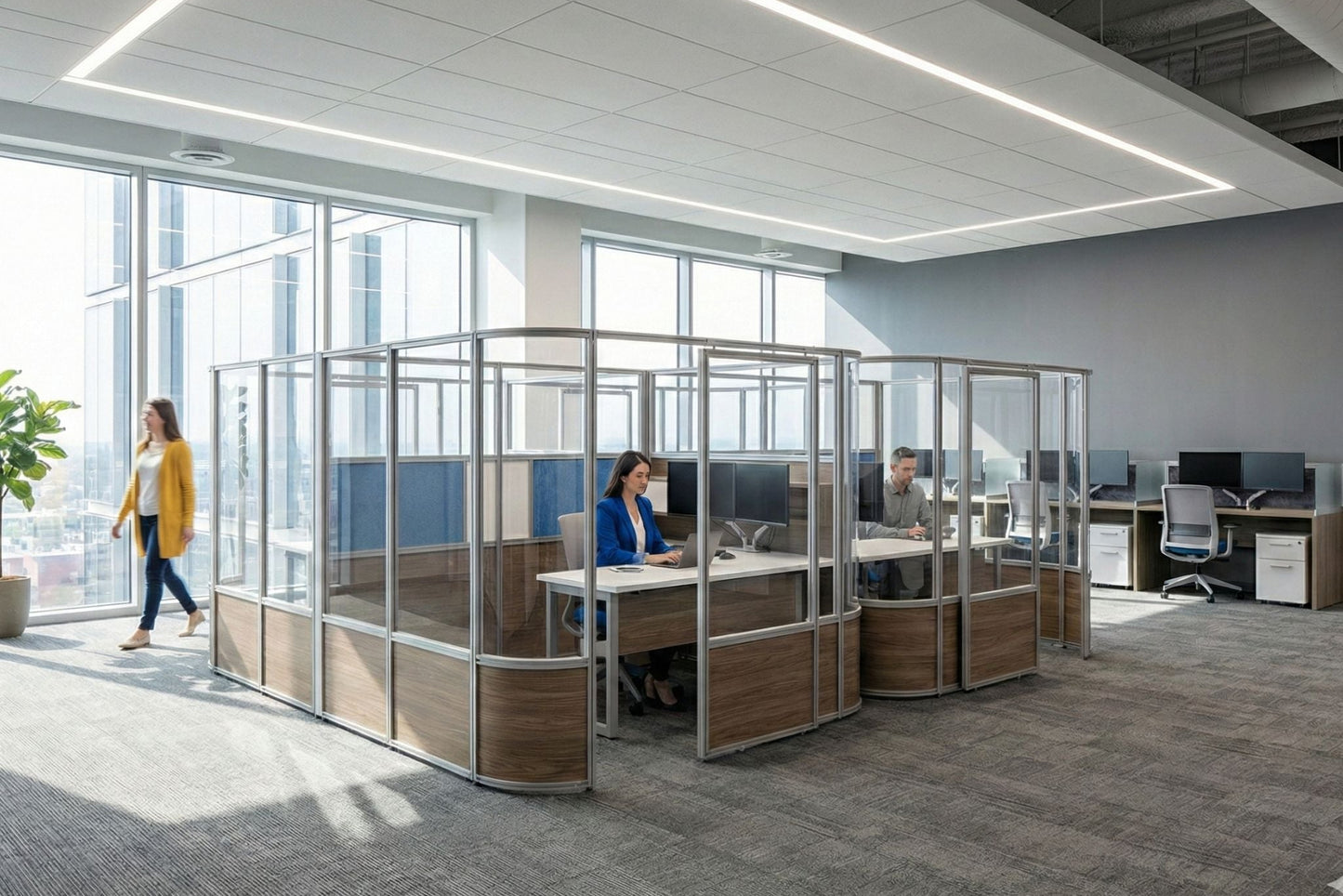Modern office with glass partitioned workstations and employees at their desks.