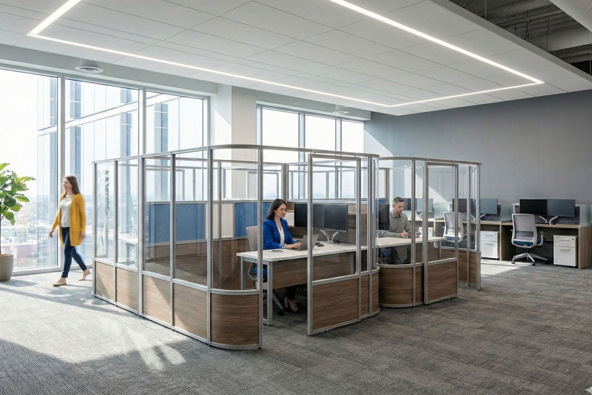 Modern office with glass partitioned workstations and employees at their desks.