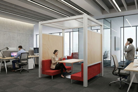 Modern office space with glass partitioned workstations and red chairs.