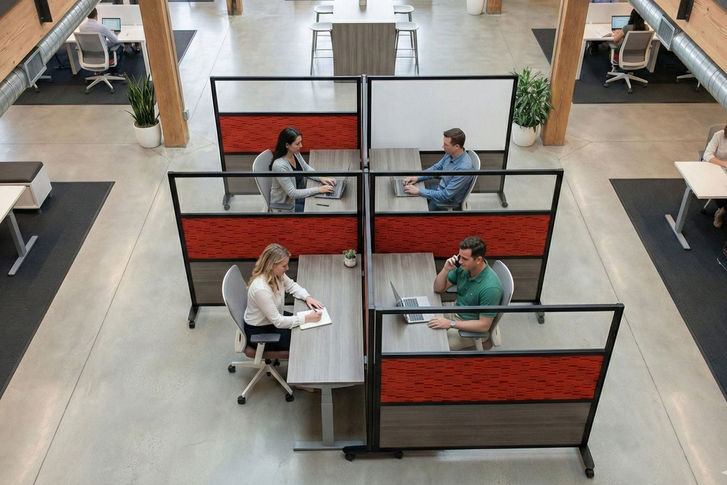 Modern office layout with workers at their desks and red and black partitioned workstations.