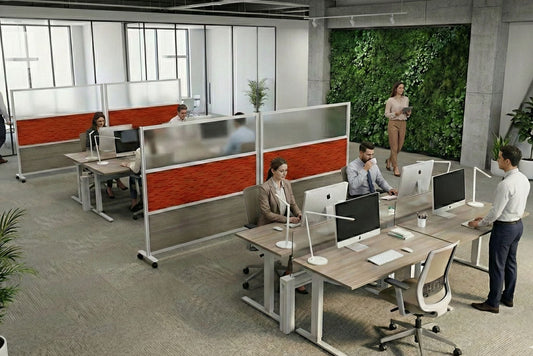 Modern office space with employees working at desks and a green wall in the background
