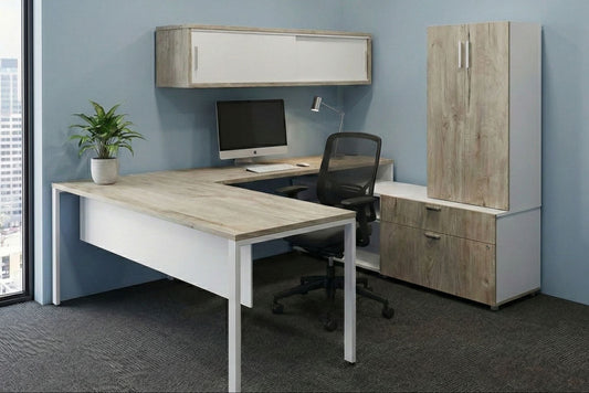 Modern office desk with computer setup and storage cabinets in a room with large windows.