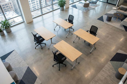 Modern office  training room space with desks and chairs near large windows